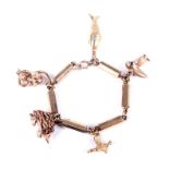 A vintage gold fancy faceted-cylinder link charm bracelet on a bolt-ring clasp with charms.