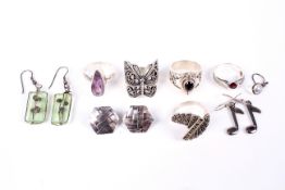 A group of five white metal rings and three pairs of earrings.