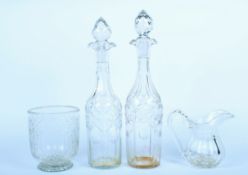 Two 19th century cut glass decanters, together with a pouring jug and a tea caddy mixing bowl.