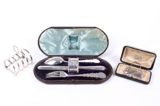 A silver toast rack, a cased christening set and a decanter label.