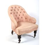 A Victorian button back pink silk upholstered armchair.