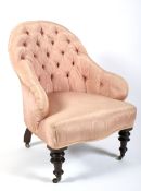 A Victorian button back pink silk upholstered armchair.