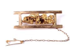 An early 20th century gold nugget and sluice box brooch.