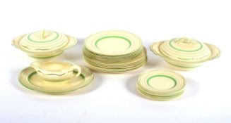 A Clarice Cliff green and gilt part dinner service.