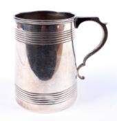 A silver tapering cylindrical tankard.