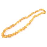 An opaque amber tumble-polished chip continuous necklace. Approx 62cm long overall, 55.
