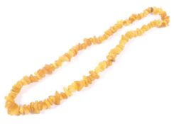 An opaque amber tumble-polished chip continuous necklace. Approx 62cm long overall, 55.