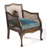 An early 20th century caned bergere armchair.