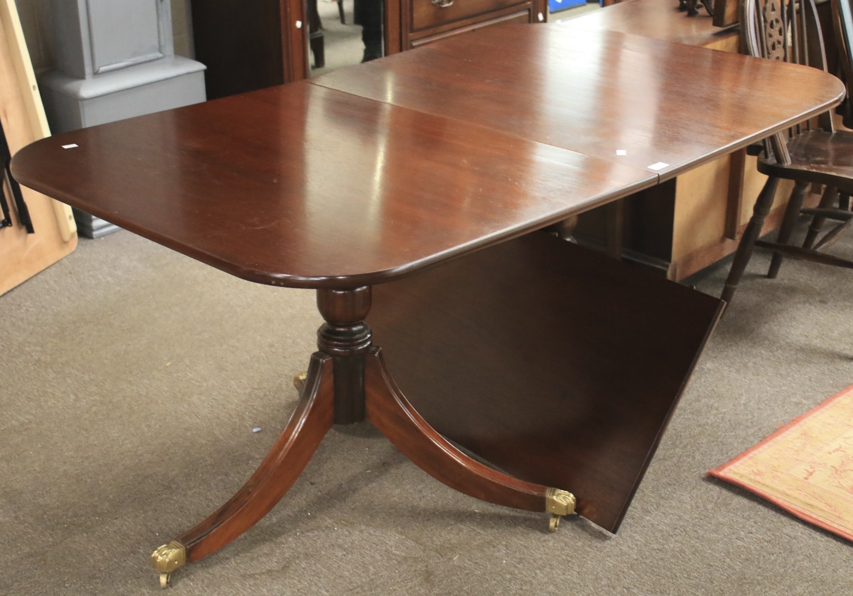 A mahogany veneer extendable dining table.