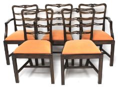 A set of five stained wooden chairs.