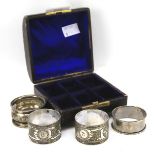 Two silver napkin rings and two plated examples, in a display case. Total silver weight 18.