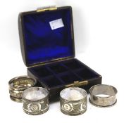 Two silver napkin rings and two plated examples, in a display case. Total silver weight 18.