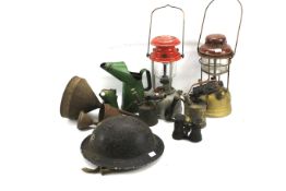 A World War II period military Brodie style helmet, two oil lamps and other items.