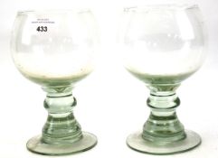 A pair of large antique glass cups.