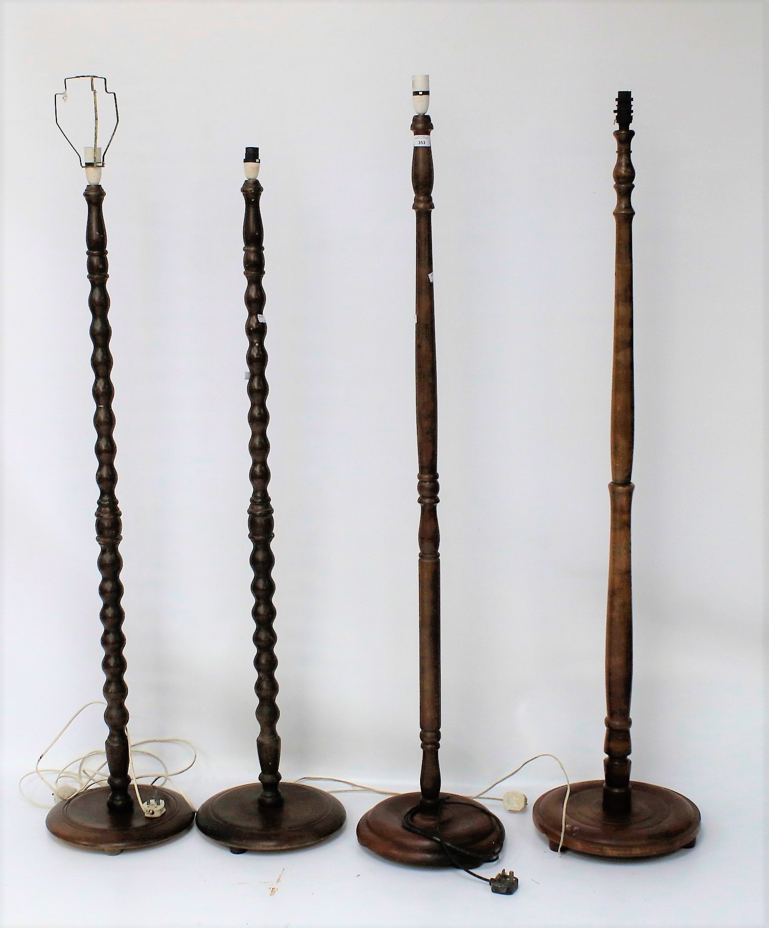 Four 20th century stained wooden standard lamps.