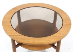A mid-century glass topped circular coffee table.