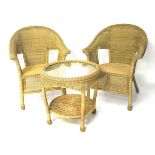 A set of two wicker chairs and a table.