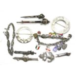 A collection of silver and weight metal brooches, badges and bracelets.