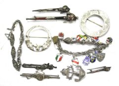 A collection of silver and weight metal brooches, badges and bracelets.