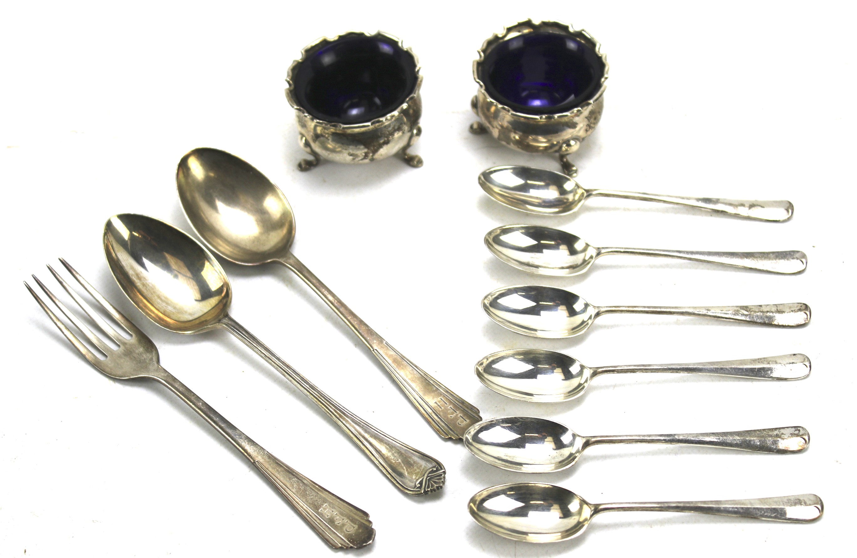 Two silver salts and glass liners and a collection of silver flatware.