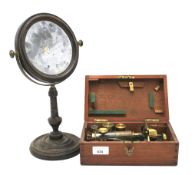 A early 20th century miniature microscope and a circular swing mirror.