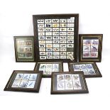 A collection of cigarette and collectors cards mounted in frames.