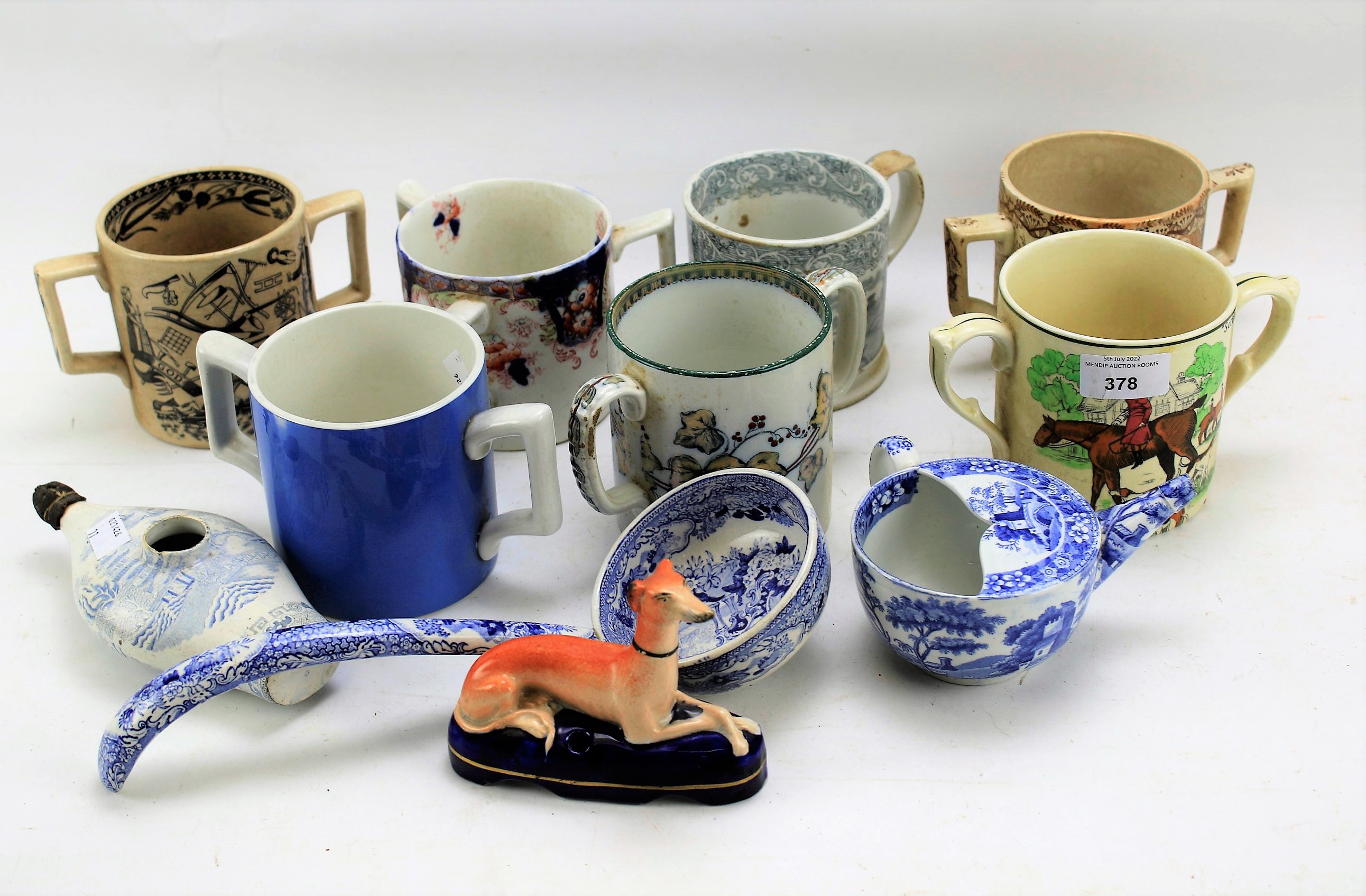 A collection of Staffordshire pottery loving cups and other items.