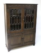 A stained oak glazed bookcase.