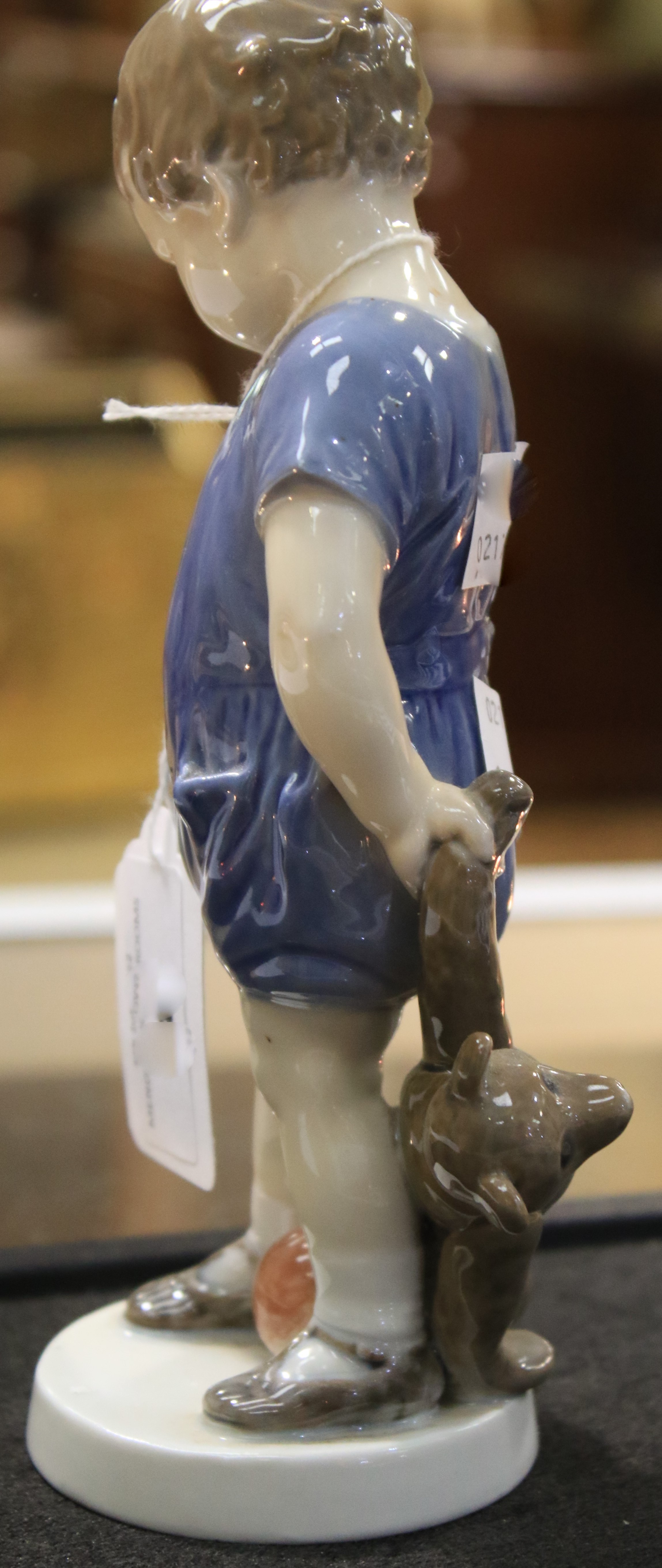 A Royal Copenhagen porcelain figure of a child holding a teddy bear. - Image 4 of 6