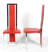 A pair of Italian high backed dining chairs in chrome with red upholstery.