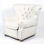 A contemporary reclining upholstered button back armchair.