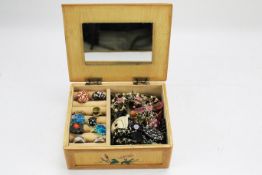 A collection of assorted costume jewellery in a wooden vintage jewellery box.