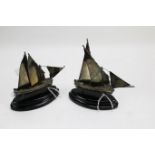 A pair of silver miniature models of sailing ships. Hallmarked, on ebonised stands, 14.
