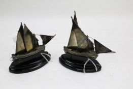 A pair of silver miniature models of sailing ships. Hallmarked, on ebonised stands, 14.