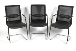 A set of three chrome and faux leather dining chairs with mesh backs in the Pieff style.