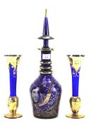 A Middle Eastern blue glass decanter and a pair of similar posy vases.