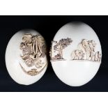 Two ostrich eggs decorated with applied African figures and a collage of African animals in relief.