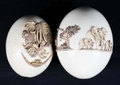 Two ostrich eggs decorated with applied African figures and a collage of African animals in relief.