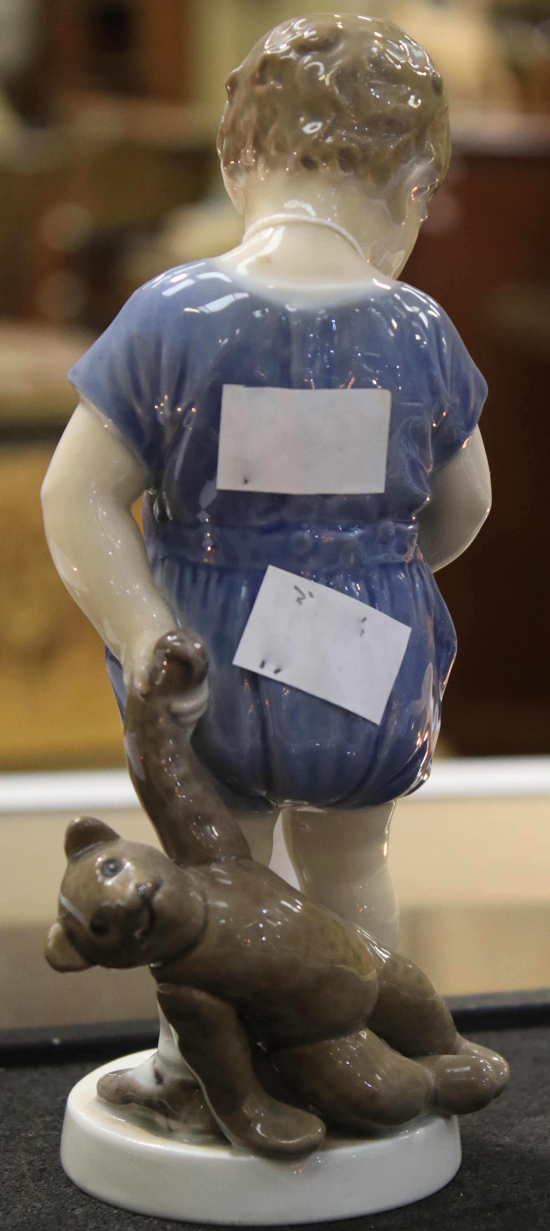 A Royal Copenhagen porcelain figure of a child holding a teddy bear. - Image 3 of 6