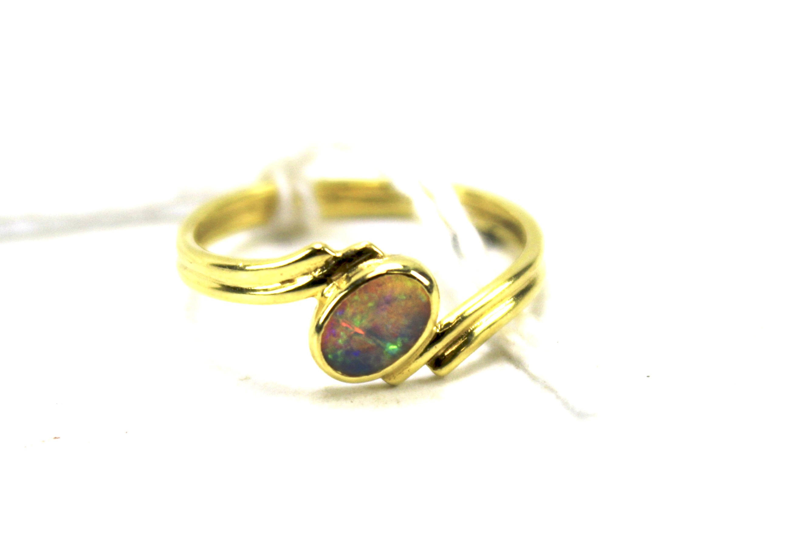 An opal and 18ct gold double banded ring. The oval stone set at a diagonal angle. Weight 1.