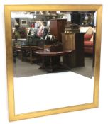 A large modern gilt framed bevelled edge wall mirror and a smaller example with pierced decoration.