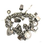 A silver charm bracelet with a heart padlock.