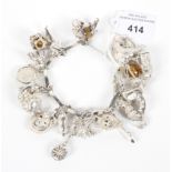 A 20th century silver charm bracelet with numerous attached charms.