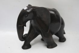 A large carved wooden figure of a stylised elephant.