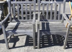 A pair of contemporary teak garden armchairs.