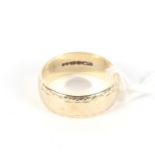 A 9ct gold wedding band. With geometric borders.