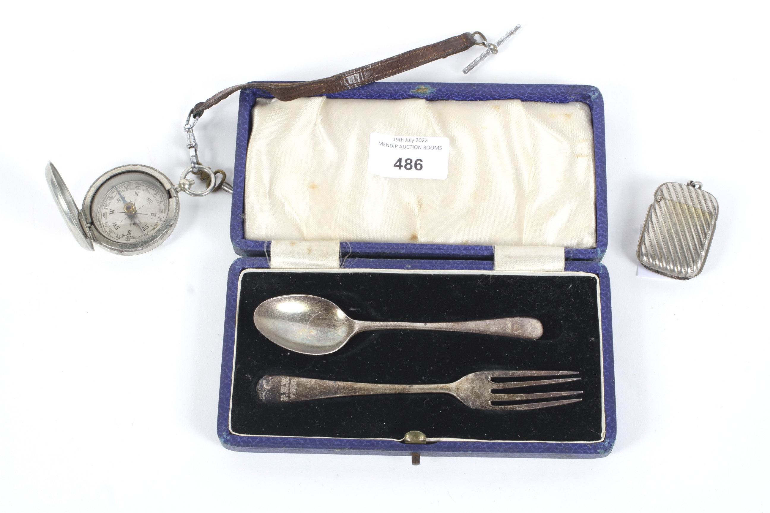 A military compass, vesta case and a silver fork and spoon set.