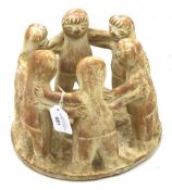 A terracotta sculpture of a group of figures (possibly Eskimos).