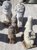 Two pairs of composite garden figures of lions and a gnome pushing a wheelbarrow.