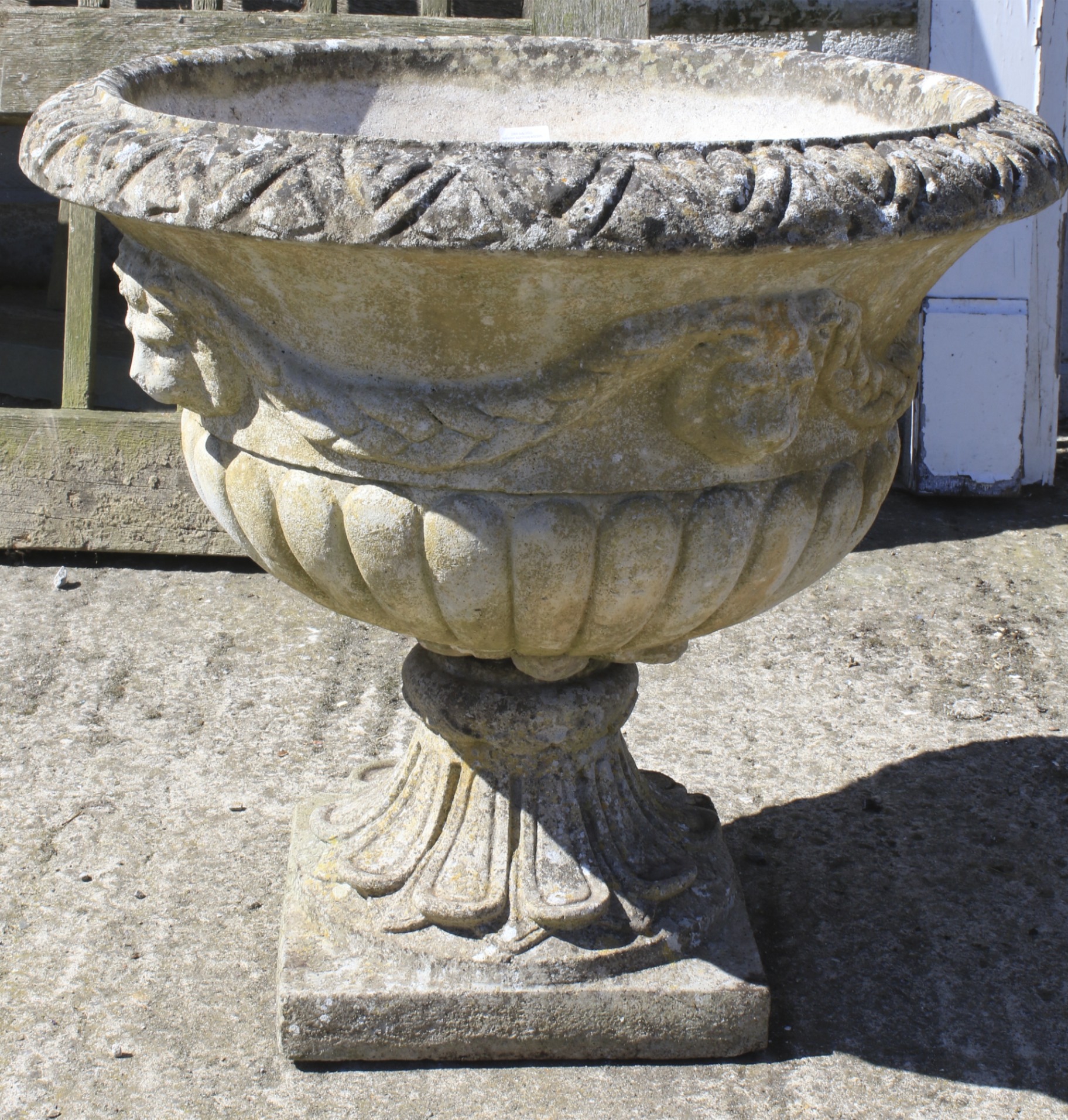 A large composite stone garden urn shaped jardiniere.